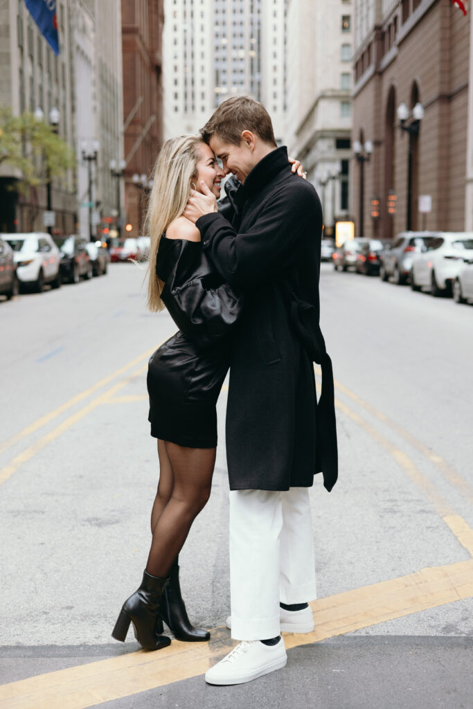 Couple embracing during engagement photoshoot in front of the Chicago Board of Trade in Chicago, Illinois. 