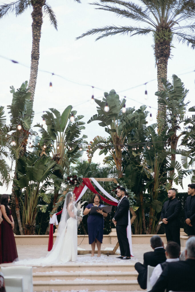 Bride and groom getting married during their ceremony at The Club at the Strand in Naples, Florida. 