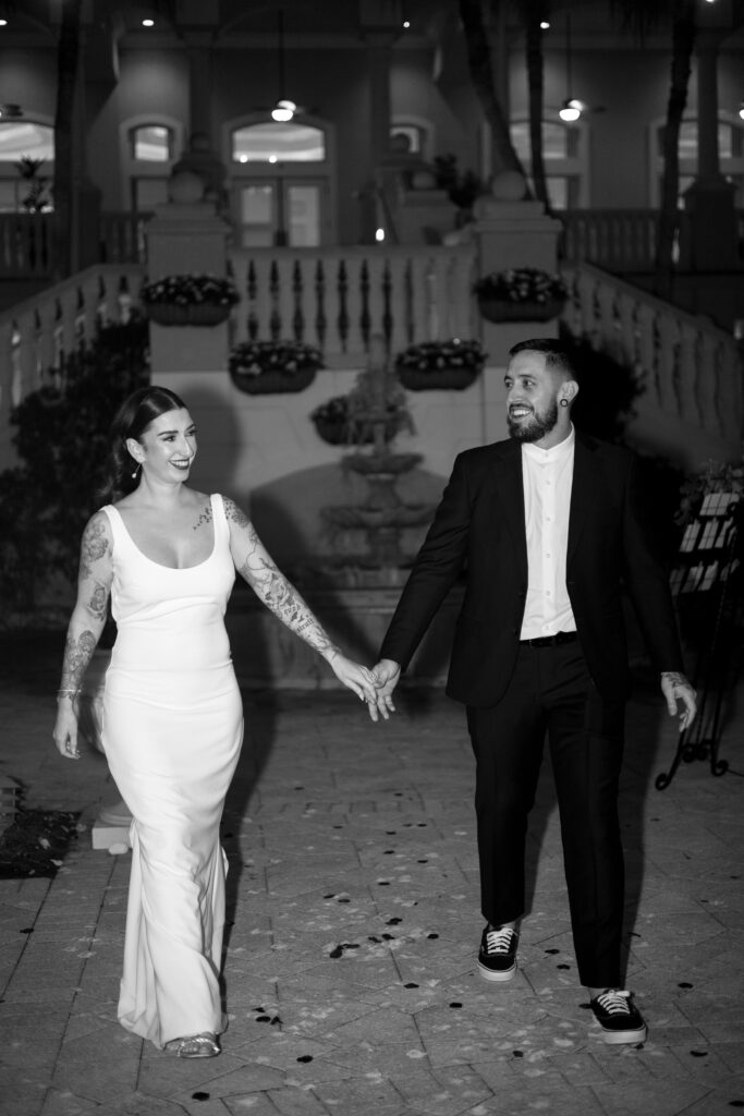 Bride and groom enter the reception hand in hand after their wedding at The Club at the Strand in Naples, Florida. 