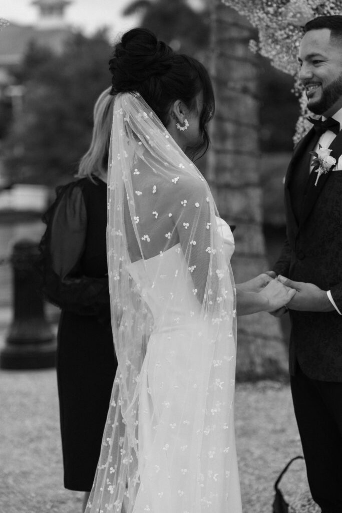 Bride has a stunning long veil during her wedding ceremony at Naples Bay Resort in Naples, Florida. 