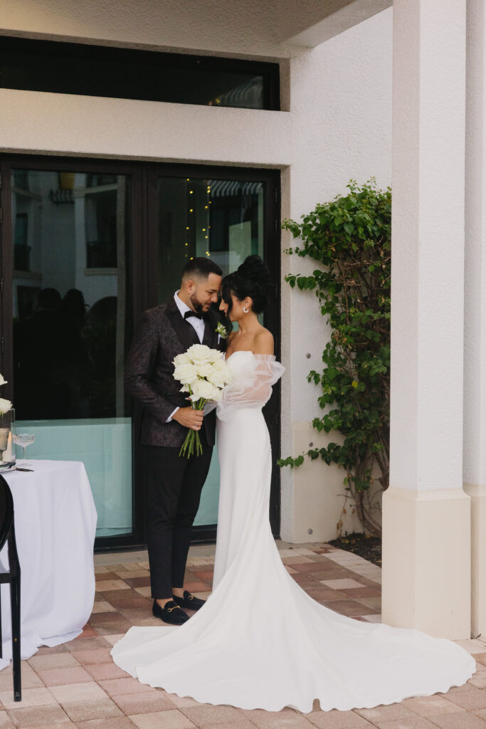 Bride and groom pose for photo during their wedding at Naples Bay Resort in Naples, Florida. 