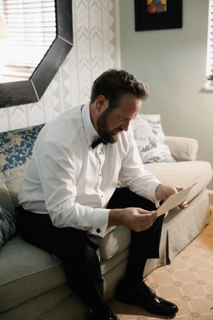 Elegant Port Royal Wedding | Priscila Del Cristo Photo Groom reading letter from bride at Naples' Port Royal wedding.