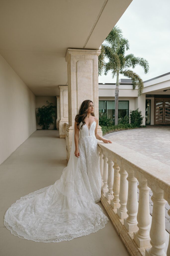 bride standing on a porch at her portrait session during the best time to get married in florida, summer month