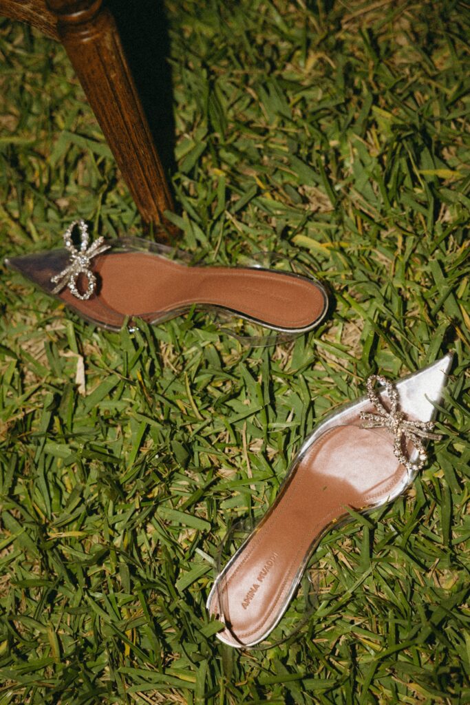 pair of bridal shoes with diamond-studded bows on the grass of a florida wedding