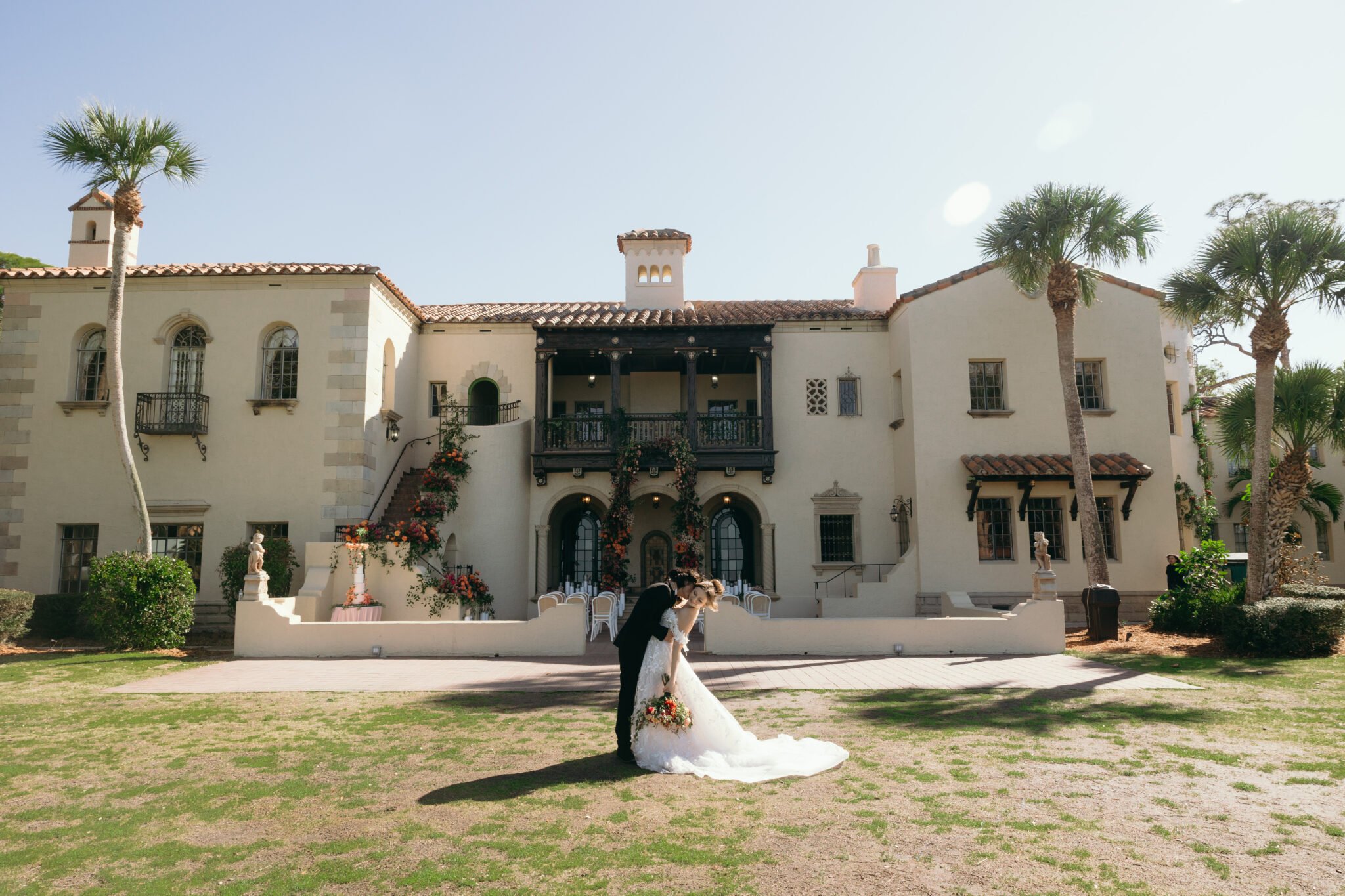 bride and groom hugging intimately in front of their florida wedding venue during their portrait session