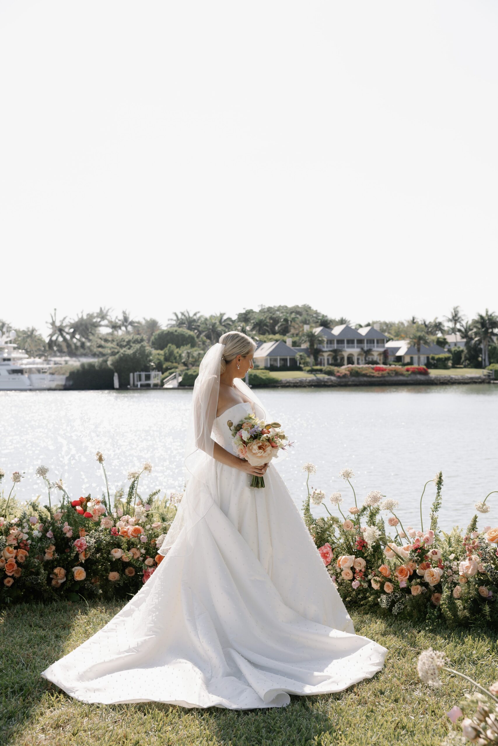 bride standing on her own with flower in her hand during her wedding day portrait session in florida