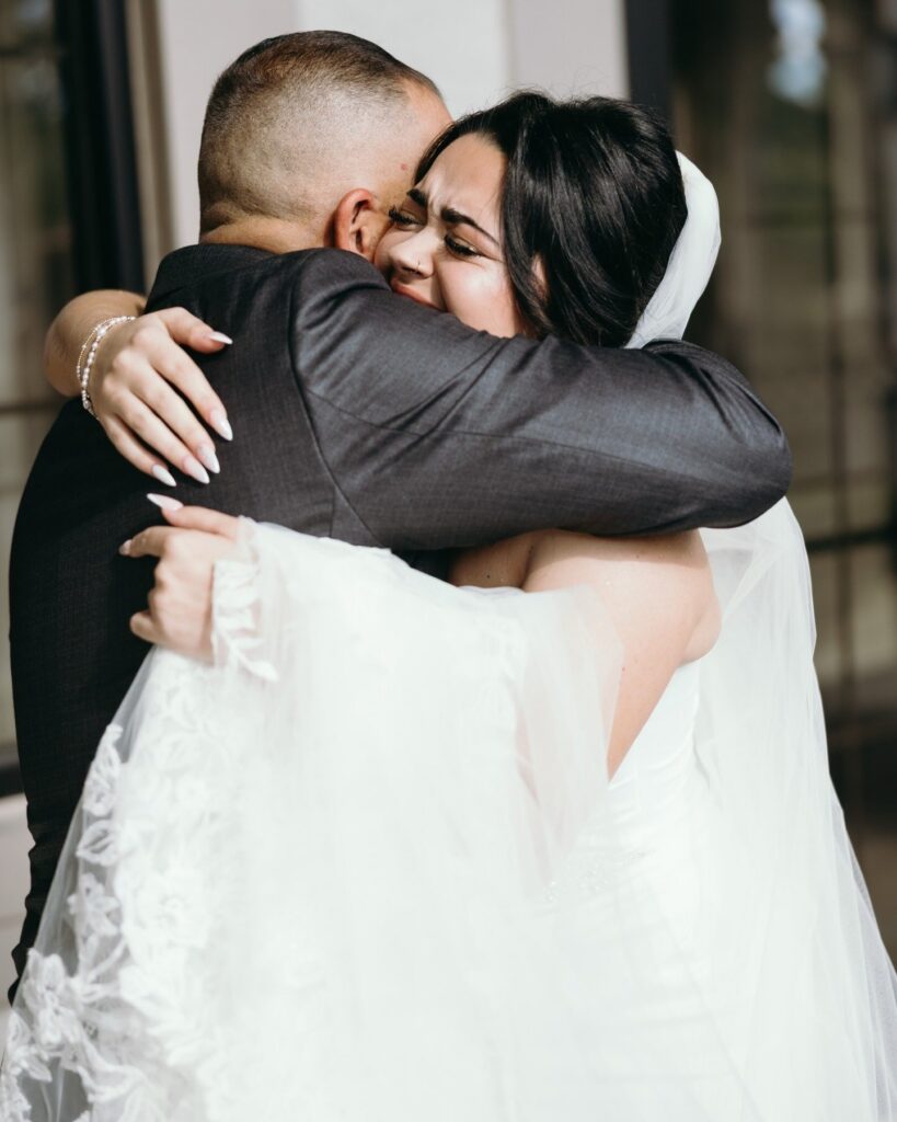 The newlyweds share an emotional embrace, celebrating the culmination of months of planning and anticipation. Their joyful expressions capture the deep connection and relief felt after exchanging vows. Wedding planners in Naples specialize in creating seamless timelines that allow couples to remain present in these meaningful moments rather than worrying about logistics. Captured beautifully by Priscila del Cristo, the image reflects the emotional heart of a Naples wedding celebration.