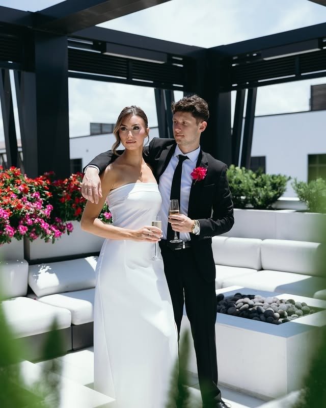Bride and groom standing together outdoors with champagne glasses at a chic modern venue in Naples Florida, showcasing luxury wedding design curated by a Naples Florida wedding planner and photographed by Priscila del Cristo.