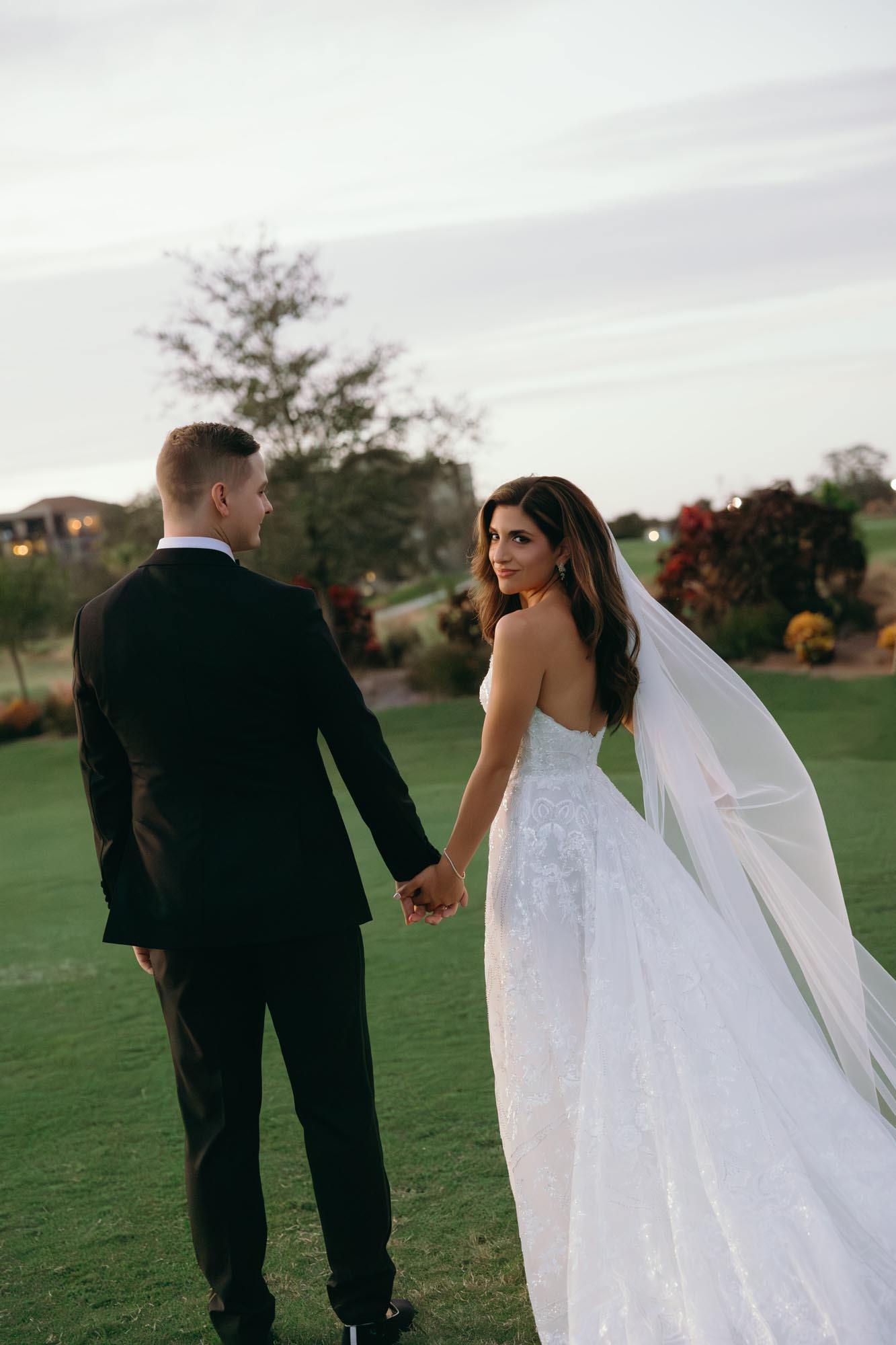 Couple holding hands at one of the top outdoor wedding venues in naples, florida, Vineyards country club