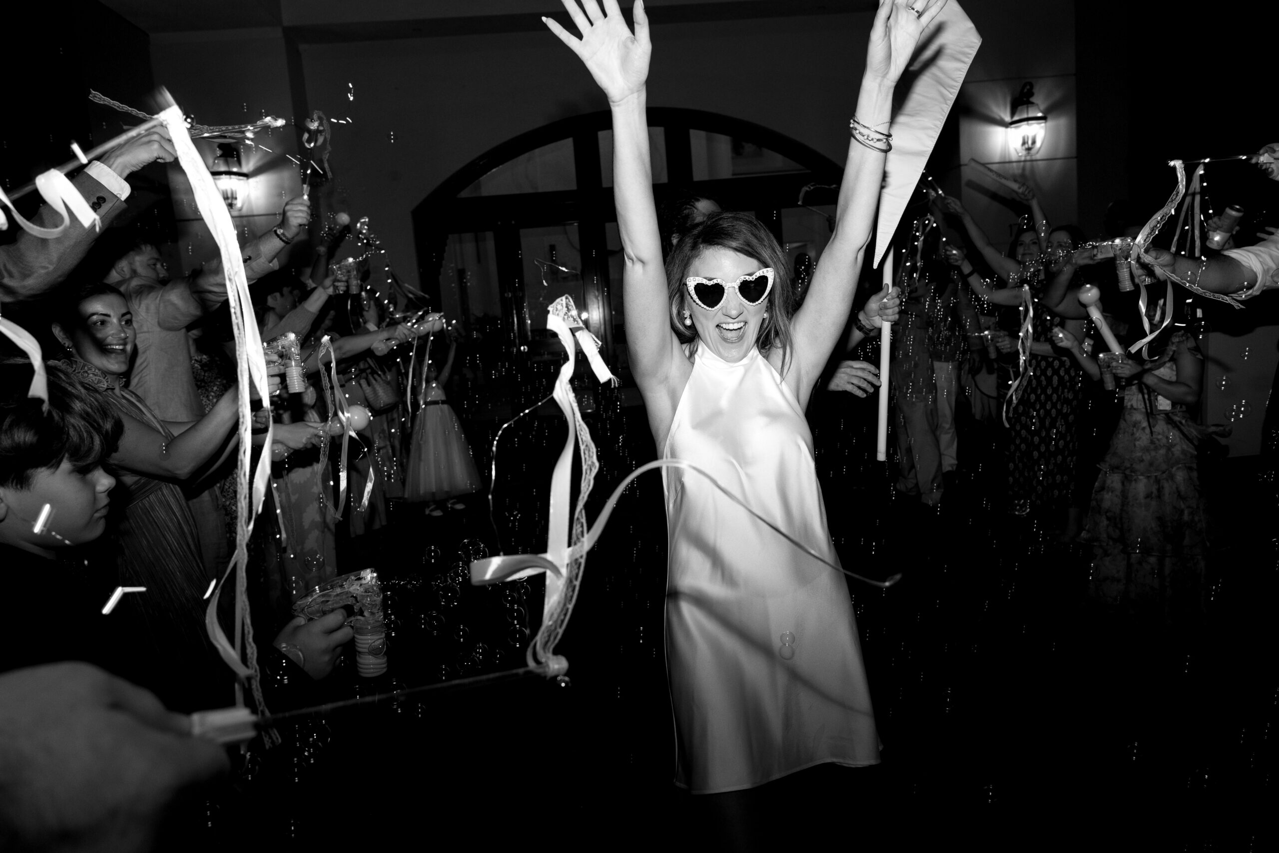 black and white image of bride celebrating at her outdoor wedding location in naples, fl