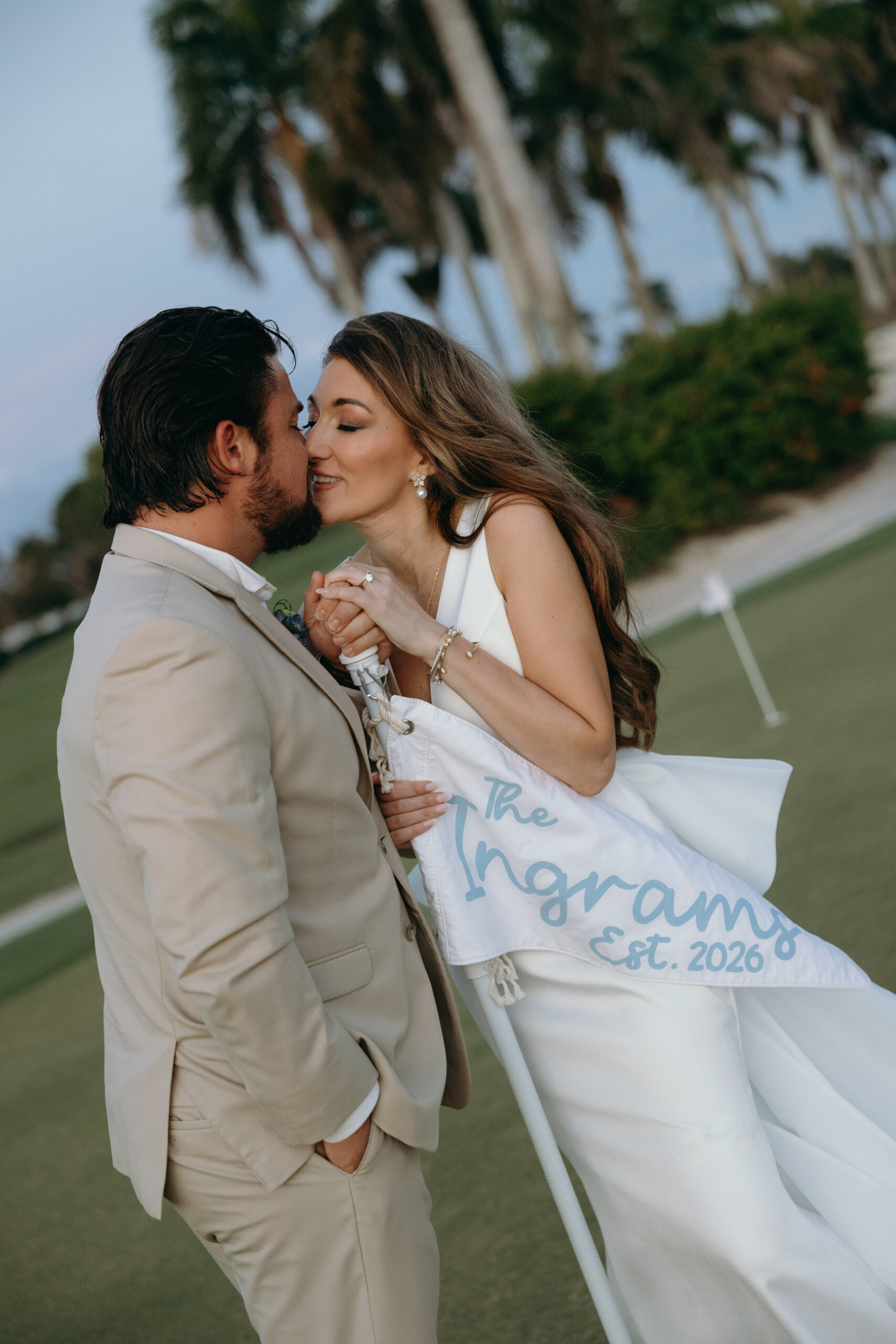 bride and groom kissing during their portait session on the lawn of one of the best wedding venues in naples, fl
