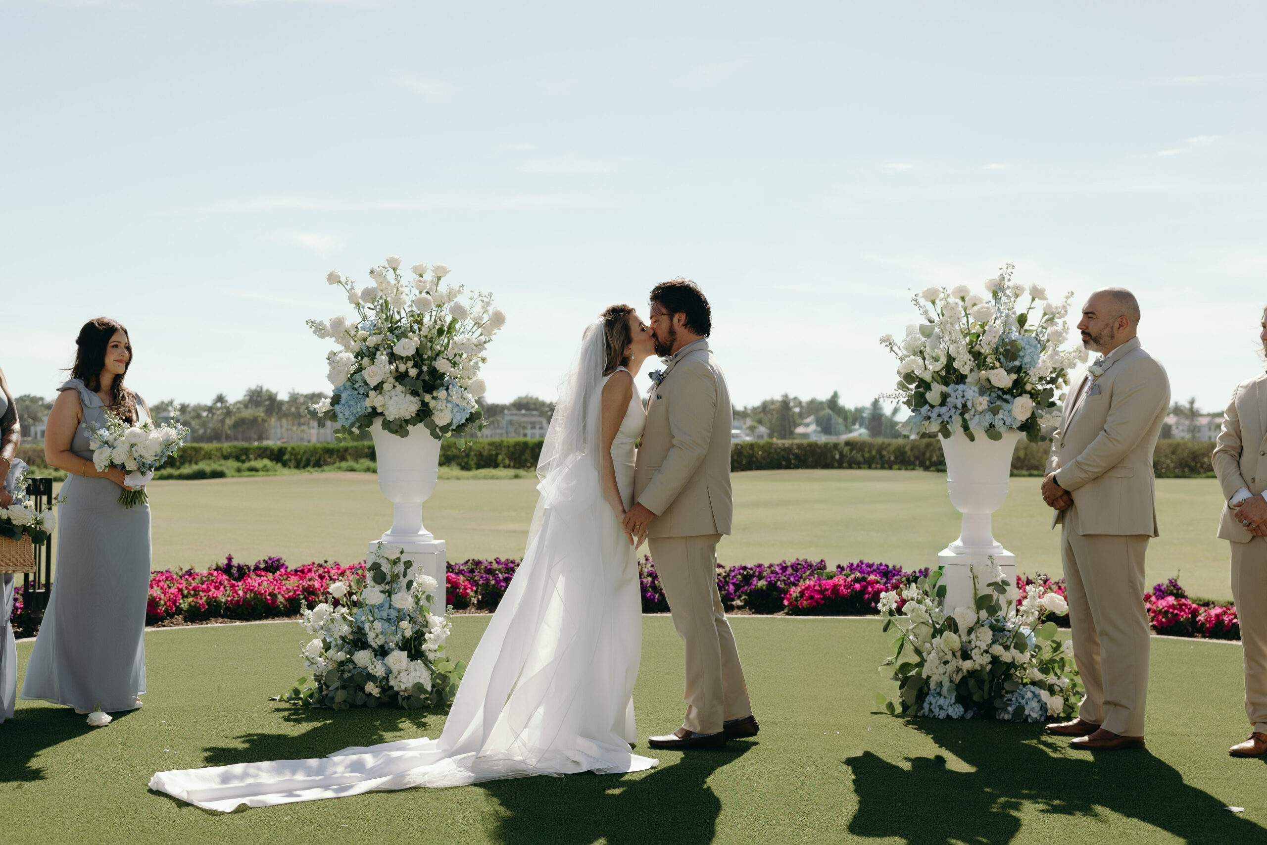 bride and groom sharing their first kiss during their outdoor wedding ceremony at one of the best outdoor wedding venues in naples, fl
