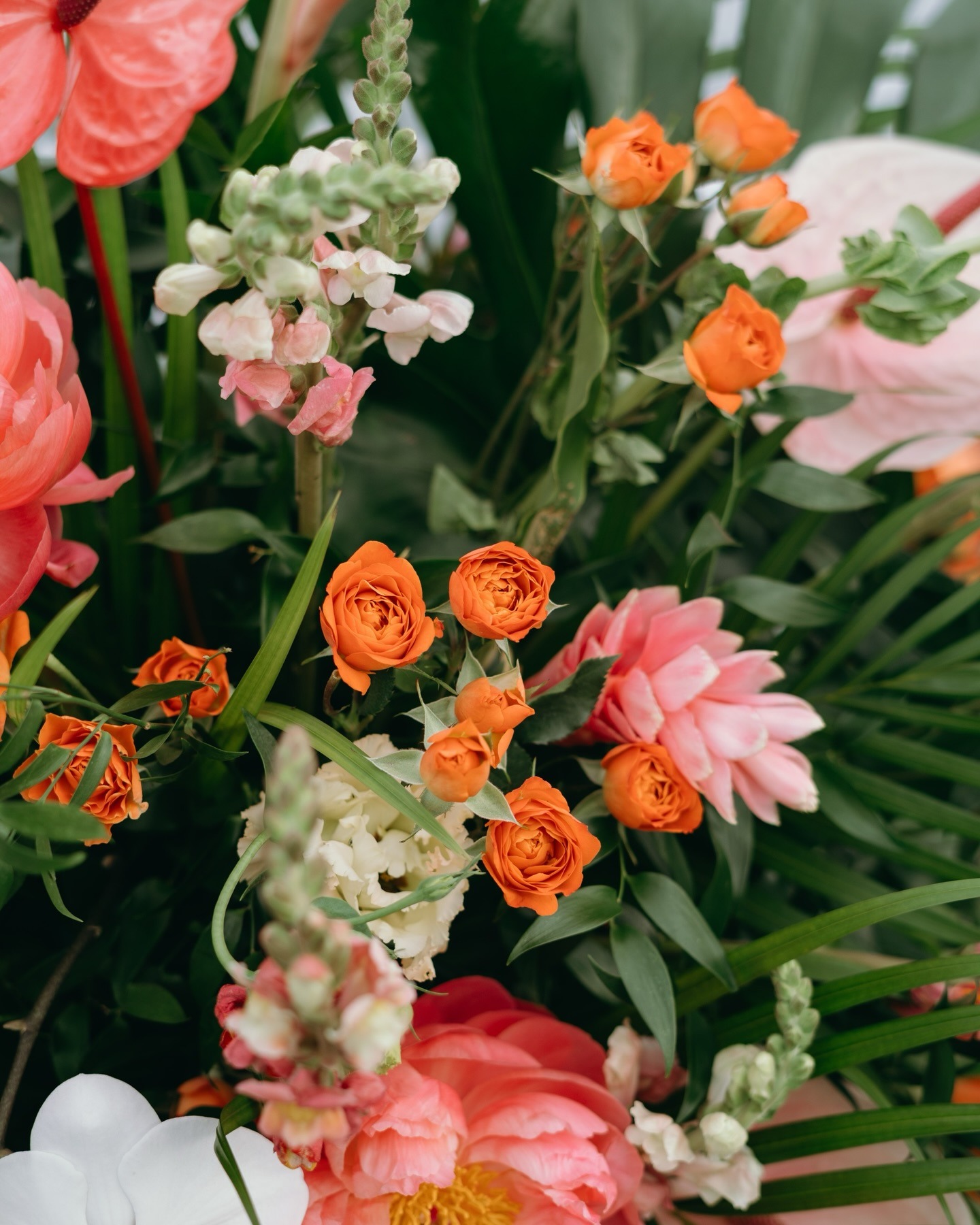 closeup of a bold orange and pink floral arrangement by one of the best wedding florists in naples
